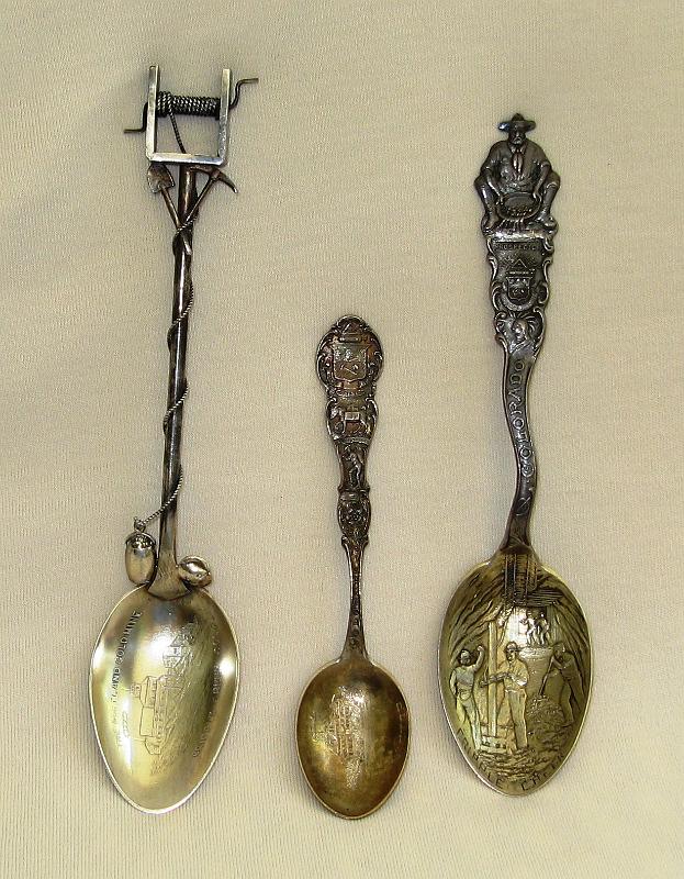 Souvenir Mining Spoons.JPG - SOUVENIR MINING SPOONS - Portland Gold Mine on left, Victor in center, and Cripple Creek on right.  Collecting souvenir spoons has been a popular hobby for many Americans since the late 1800s when this European fad swept the nation.  And mining artifact collectors are no different.  Many enjoy collecting spoons with mining themes such as the ones shown here.  Although I haven’t been bitten by the spoon bug yet, I do like Colorado mining history so these spoons are of interest to me.  By way of a little history, souvenir spoons grew out of the birth of leisure tourism in Europe around the mid-1800s. Wealthy Americans on a Grand Tour of Europe brought home these souvenirs marked with the names of cities and some of the famous landmarks they had seen.  The first souvenir spoons produced in the United States were products of well-traveled silversmiths. The inaugural souvenir spoon was produced in 1889 by Galt & Bros of Washington D.C. It featured a profile of George Washington and was created to mark the 100th anniversary of his presidency. It was shortly followed by the Martha Washington spoon.  A year or so later the most famous collector’s spoon was designed, sparking a national obsession that lasted until World War One.  In 1890 jeweler Seth F. Low visited Germany and purchased several unusual spoons. Upon his return he designed the Salem Witch Spoon for his father’s company and it was trademarked on January 13, 1891. Low described the design as featuring "the raised figure of a witch, the word Salem, and the three witch pins of the same size and shape as those preserved in the Court House at Salem”. Several thousand were sold.  The interest in souvenir spoons suddenly exploded.  At the end of 1890, there were only a handful patented or in production in America. Around half a year later, hundreds of souvenir spoon patterns were being produced to commemorate American cities and towns, famous people, historical events and significant events of the time.  The Golden Age of souvenir spoons had begun.  By 1893 the Chicago World Fair also known as the Columbian Exposition lifted souvenir spoon collecting to a whole new level. Along with 27 million visitors, the fair brought spoon collecting national exposure.  Some reports say more commemorative spoons were produced for the Columbian Exposition than for any other event in history.  The 19th century was a time of immense growth in the United States' economy. It was the age of industrialization with the rapid acceleration of technology and the invention of mass production techniques. The production of souvenir spoons became more efficient and the volume of goods increased.  Over the next 30 years every expo, fair and event was an opportunity to create a souvenir spoon.  Mining towns, mines and mining events joined in to create intricate designs, beautiful engraving and interesting themes.  By the advent of World War One, however, the appetite for souvenir spoons had waned and by the end of the war it had almost disappeared.  Today it is once again a popular hobby and mining artifact collectors are still on the hunt for elusive mining spoons.